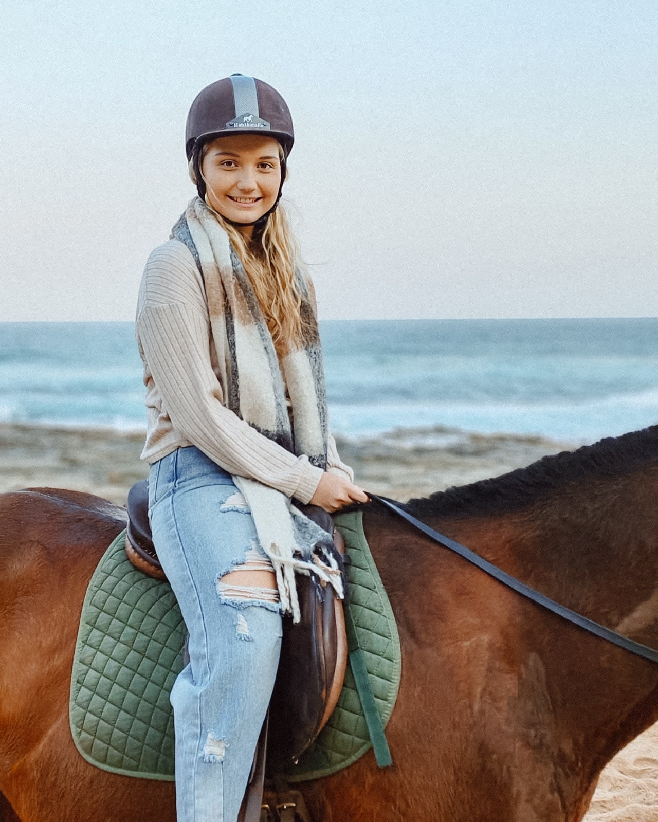Rider wearing a provided helmet on a beach outride